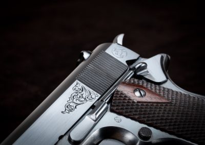 Photo of a Turnbull-made Model 1911 replica pistol, featuring hand engraving and period-correct charcoal bluing