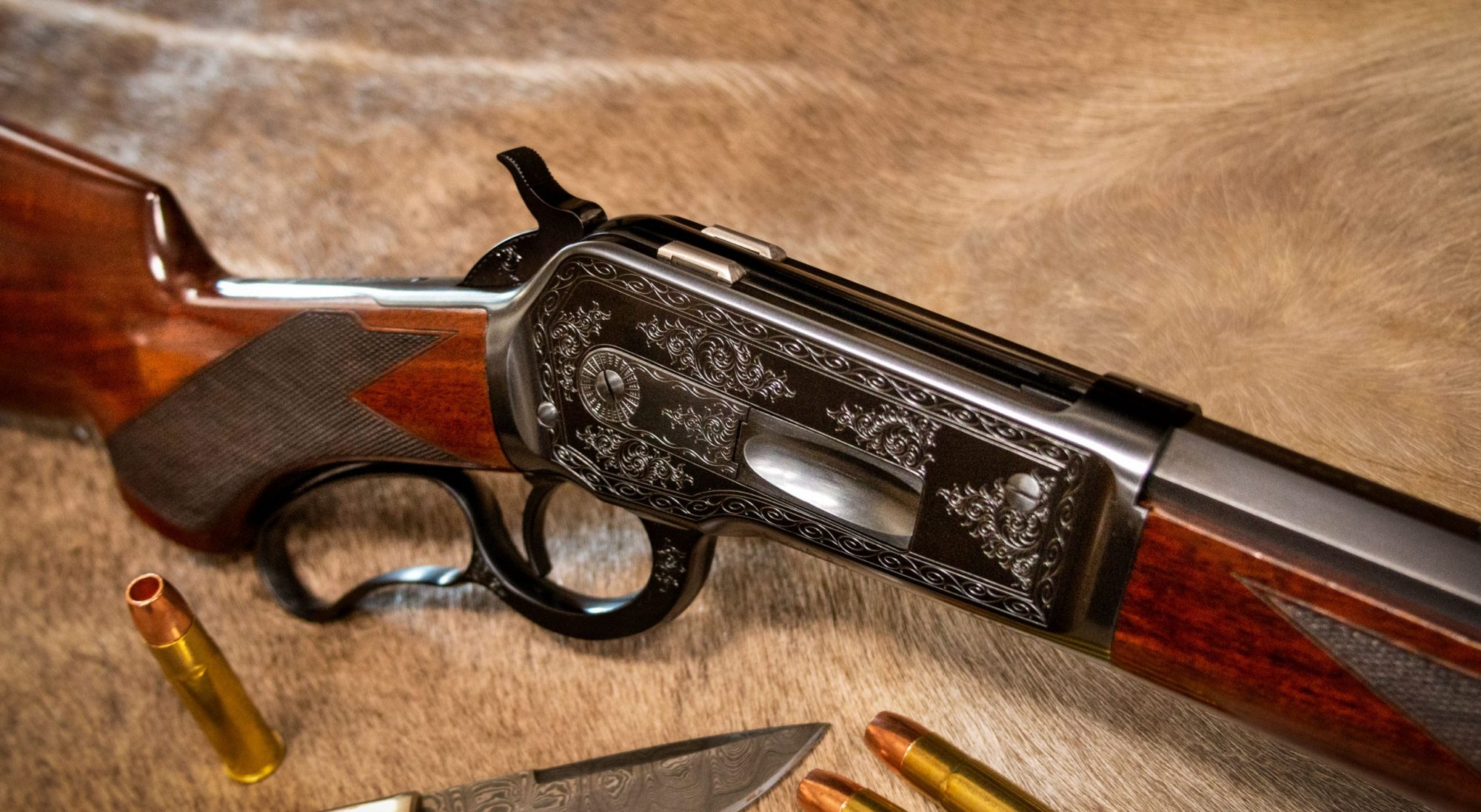 Photo of a Turnbull Model 1886, a period-correct reproduction of the famous Winchester Model 1886, featuring hand engraving and charcoal blue finish