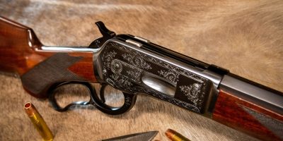 Photo of a Turnbull Model 1886, a period-correct reproduction of the famous Winchester Model 1886, featuring hand engraving and charcoal blue finish
