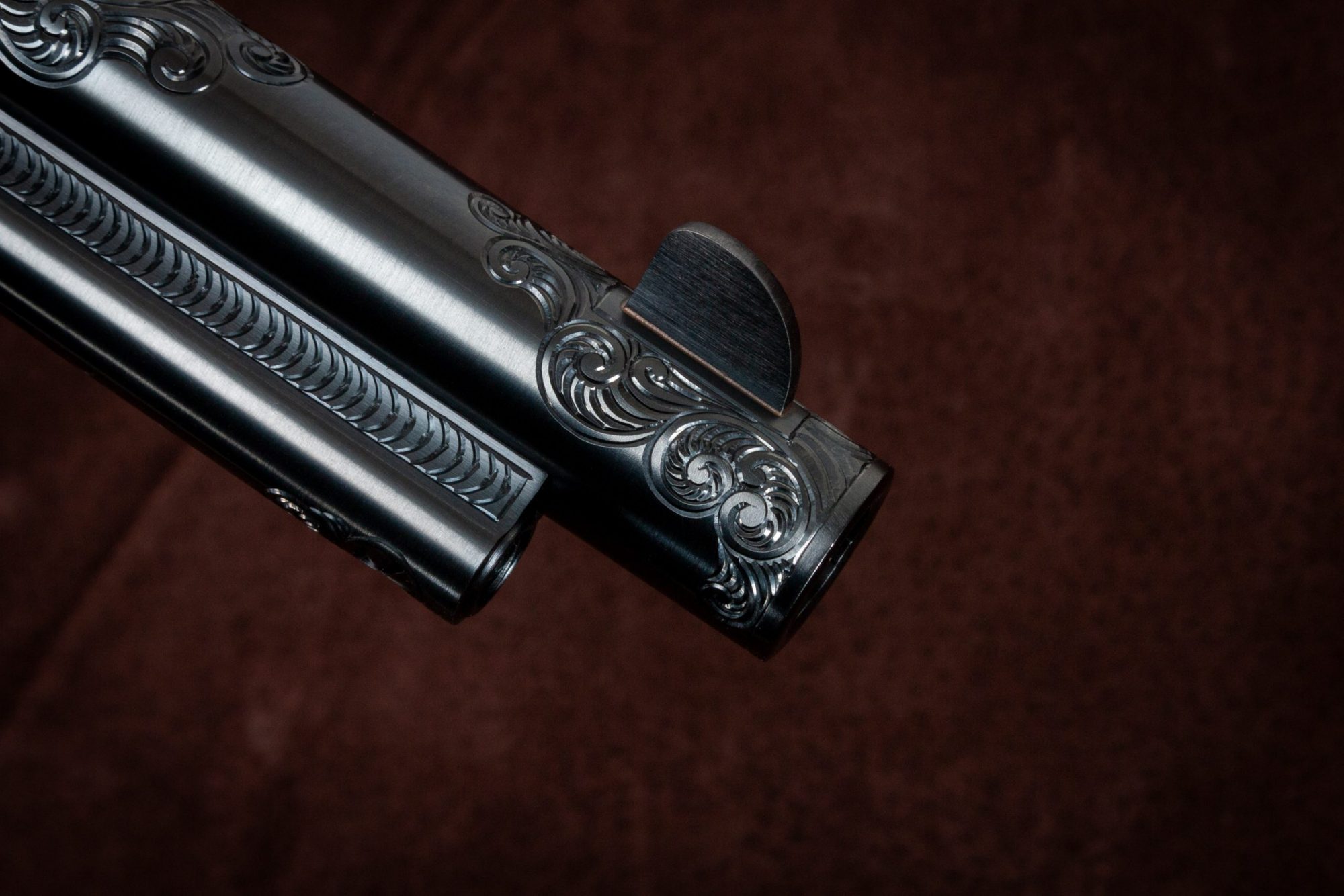 Photo of an engraved Colt SAA reproduction revolver, made by Turnbull Restoration, featuring bone charcoal color case hardening