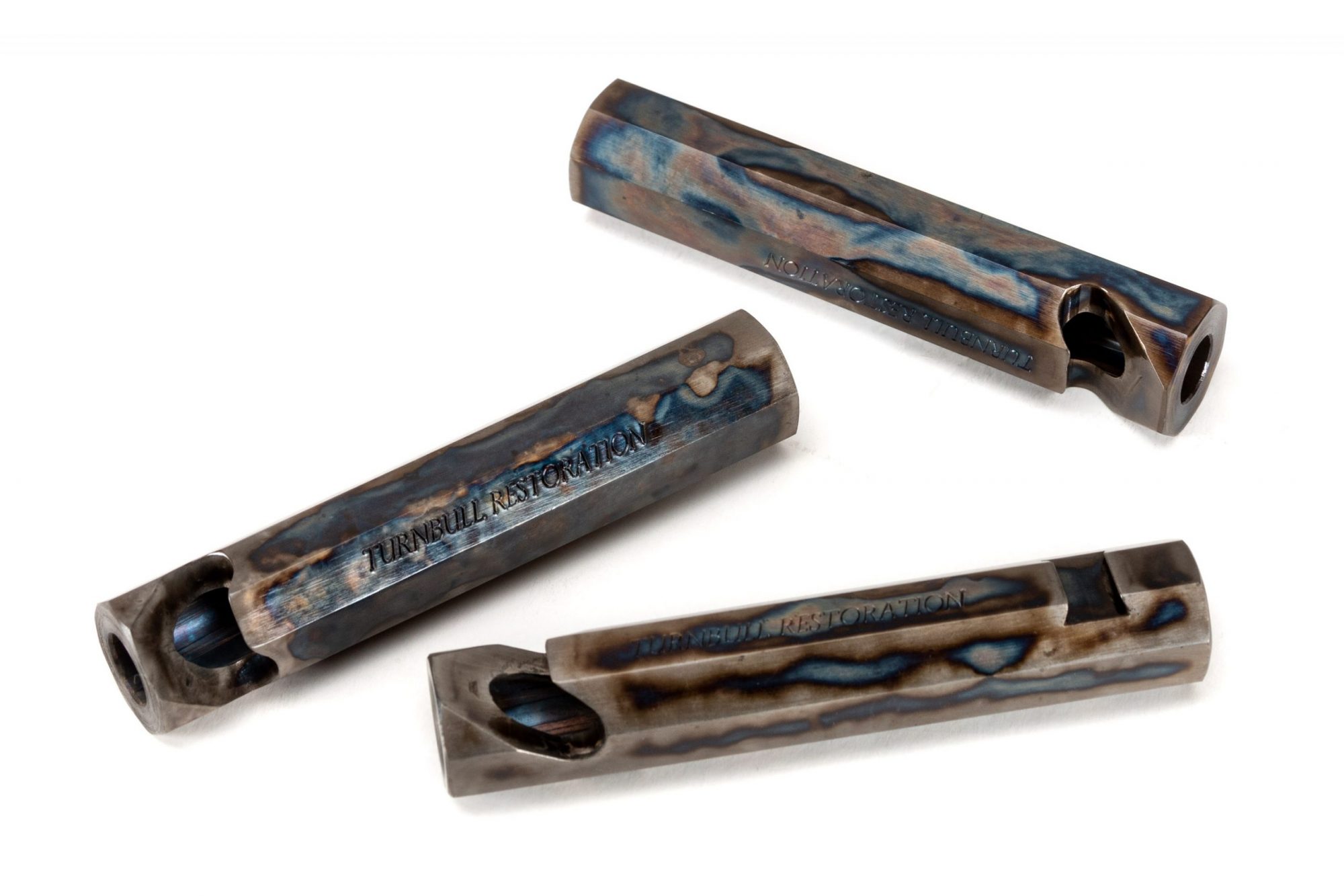 Photo of color case hardened bottle openers, featuring traditional bone charcoal color case hardening by Turnbull Restoration