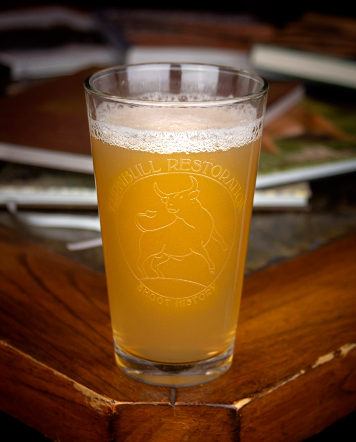 Photo of a pint glass featuring Turnbull Restoration logo in frost etching