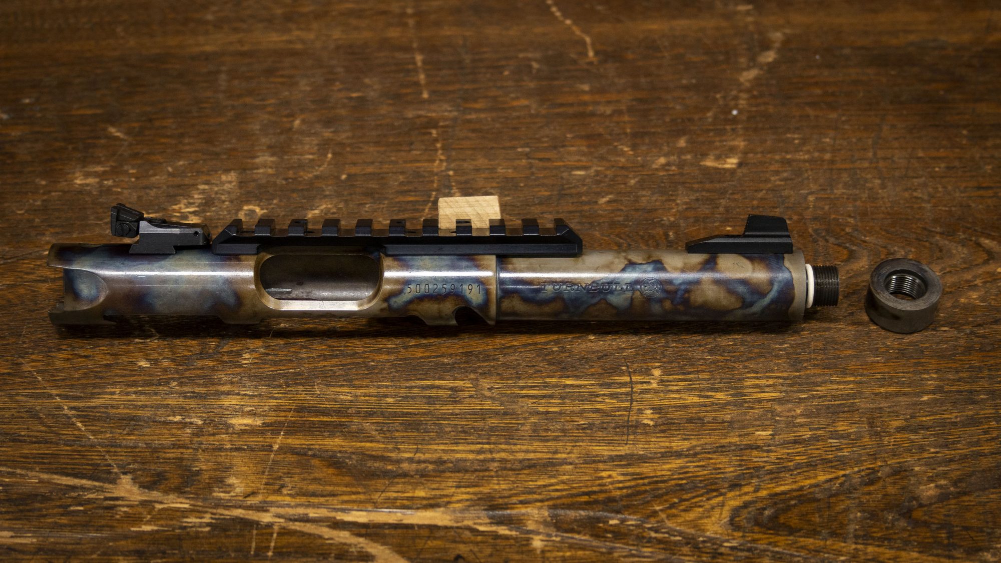 Photo of a color case hardened, threaded Ruger Mark IV barrel with Picatinny rail
